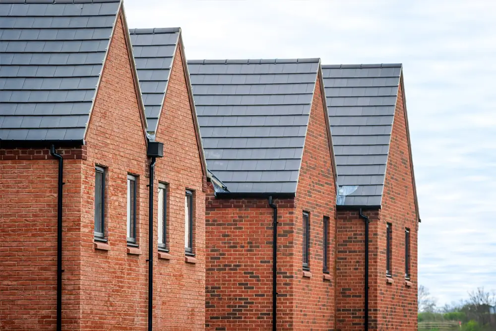Row of new-build brick homes with pitched roofs, illustrating typical residential development requiring an energy statement